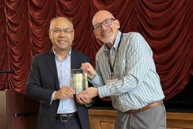 Chaowei (Phil) Yang received his award from UCGIS President Jeffery Hamerlinck at the UCGIS Symposium in Laramie, Wyoming in June 2025. Photo provided.